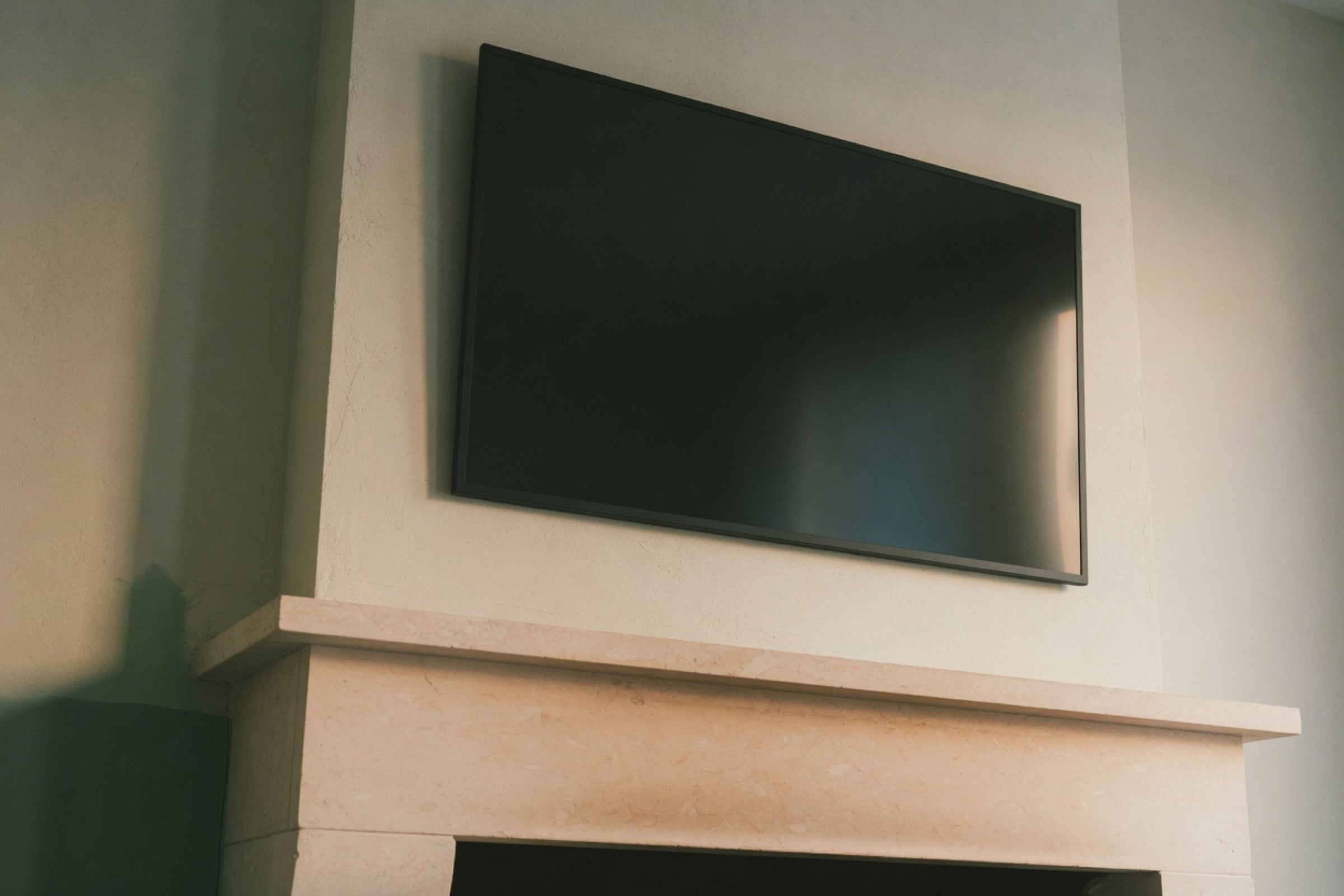 A fireplace mantel with warm air rising, the place a wall-mounted TV would sit