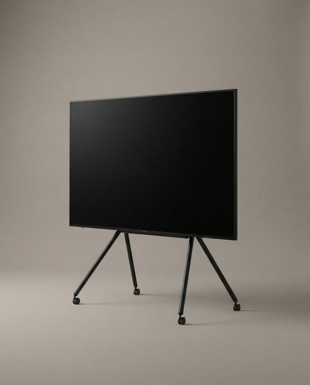 Black STUDIO TV stand from the front, splayed steel legs and casters