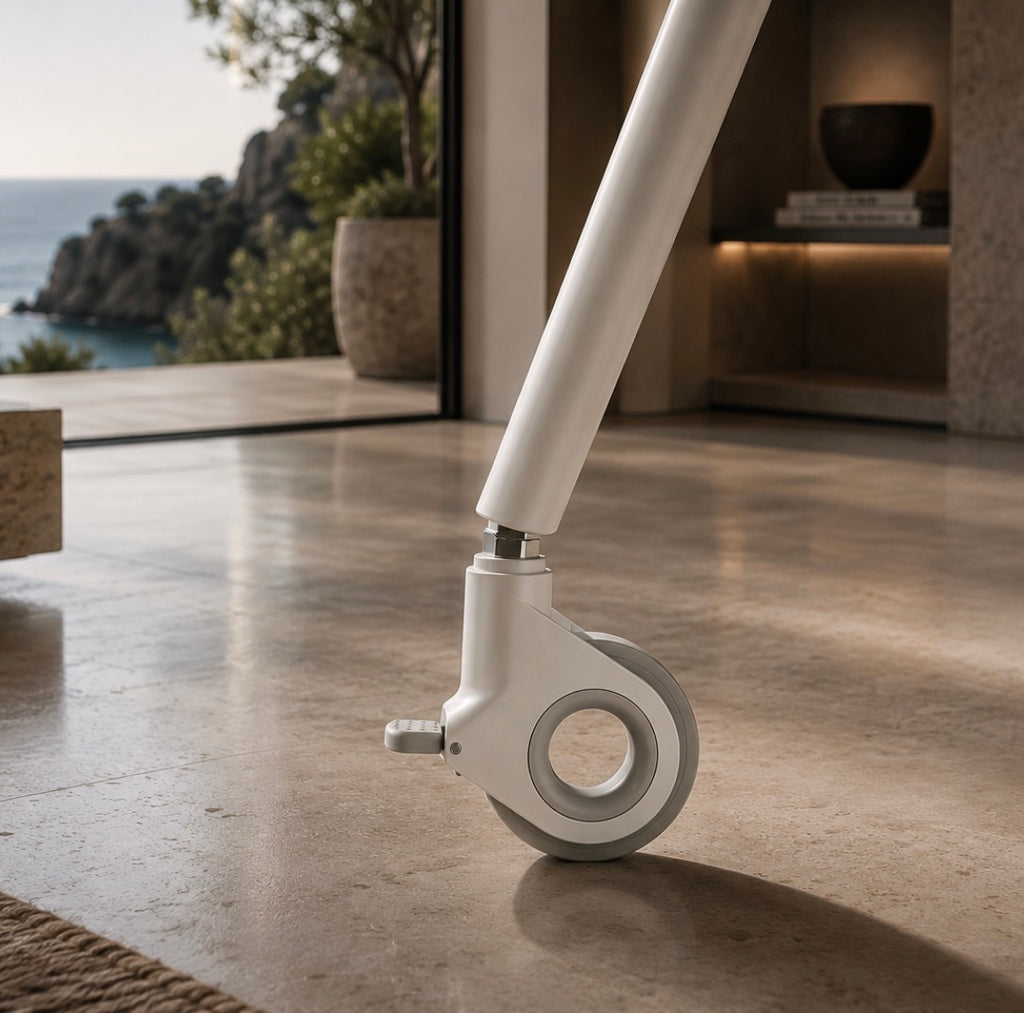 Close-up of a locking caster on the white STUDIO TV stand